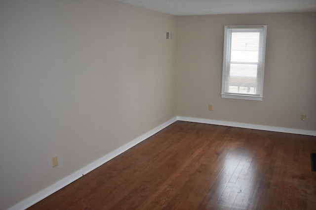 unfurnished room featuring a textured ceiling and dark wood-type flooring