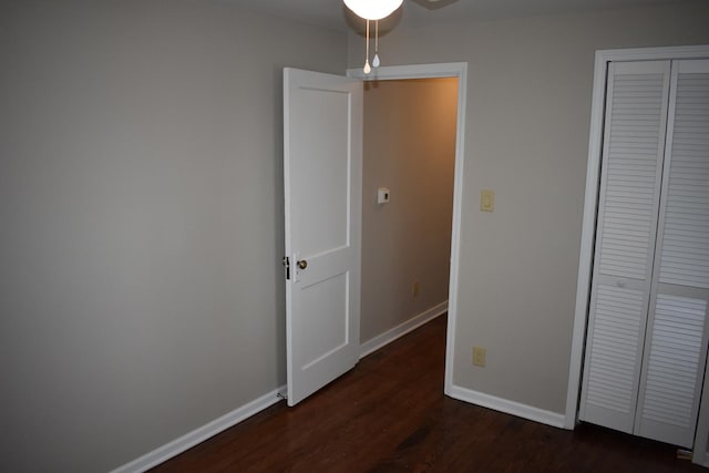 unfurnished bedroom featuring dark hardwood / wood-style floors and a closet