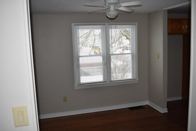 unfurnished room featuring a textured ceiling, ceiling fan, and dark wood-type flooring