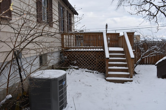 view of snow covered exterior with central AC and a deck