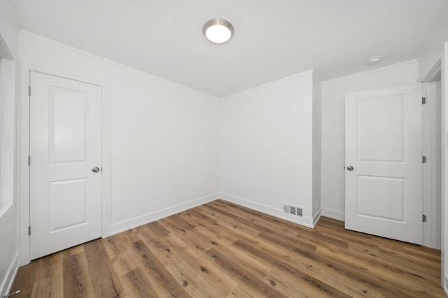 unfurnished room featuring hardwood / wood-style floors and ornamental molding