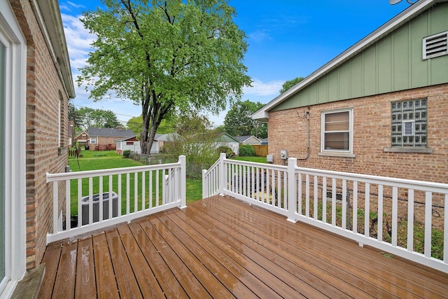 deck featuring central AC unit and a yard