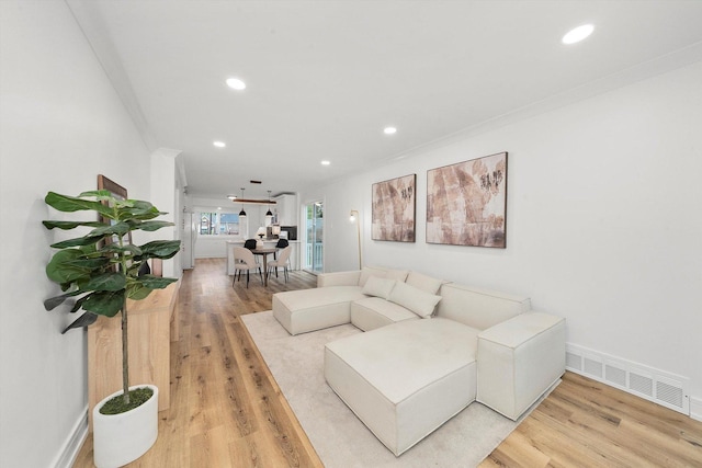 living room featuring wood-type flooring and crown molding