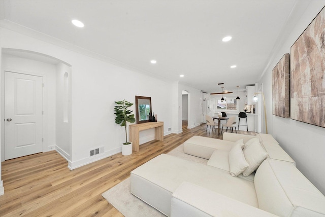 living room featuring light hardwood / wood-style flooring and crown molding