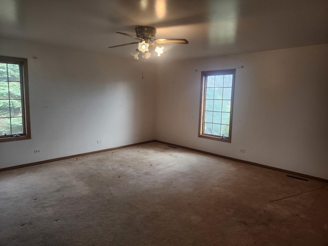 carpeted spare room with ceiling fan and a healthy amount of sunlight