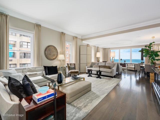 living room featuring dark hardwood / wood-style flooring, a water view, plenty of natural light, and crown molding