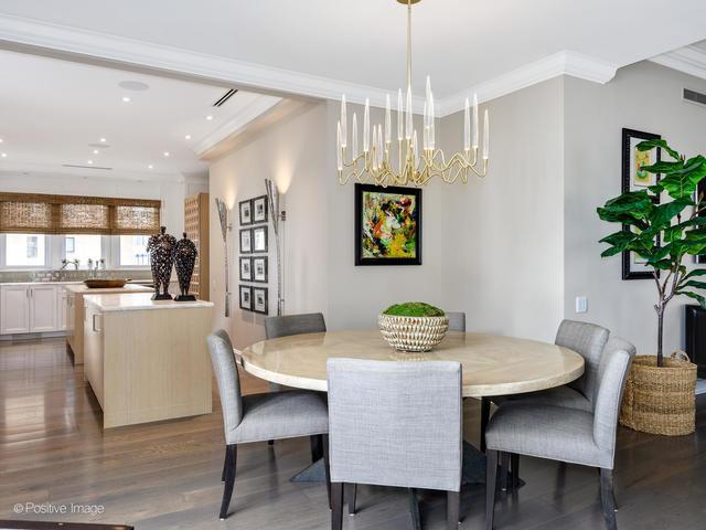 dining space featuring hardwood / wood-style flooring, crown molding, and an inviting chandelier