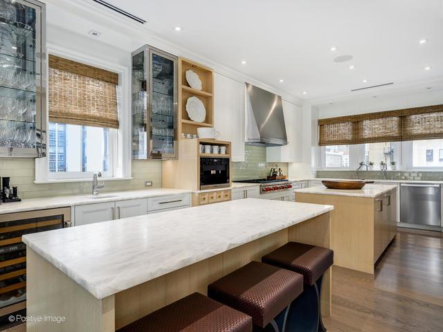 kitchen with dishwasher, a center island, white cabinets, wall chimney range hood, and sink