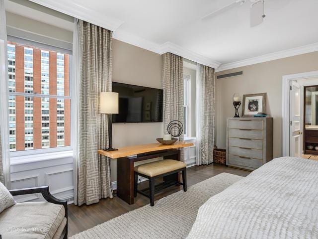 bedroom featuring multiple windows, ornamental molding, ceiling fan, and dark wood-type flooring