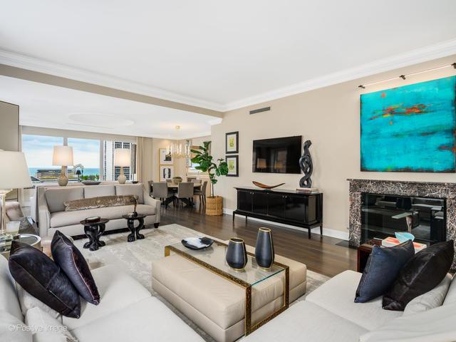 living room featuring hardwood / wood-style floors, ornamental molding, and a fireplace