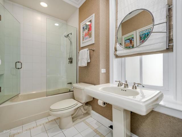 bathroom with tile patterned floors, toilet, and combined bath / shower with glass door