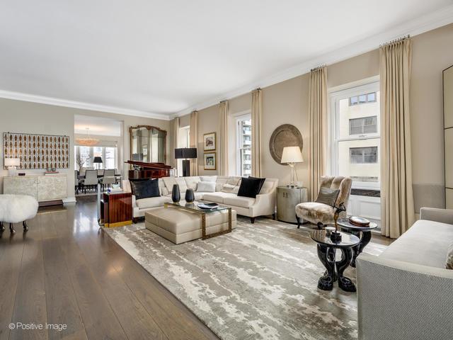 living room with wood-type flooring, ornamental molding, and a wealth of natural light