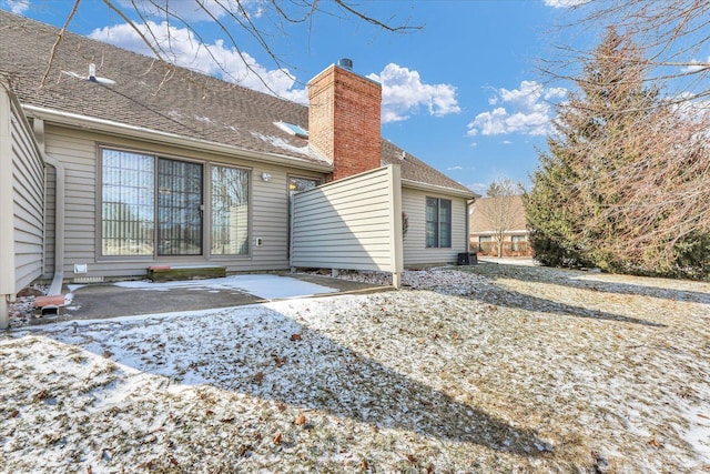 view of snow covered back of property