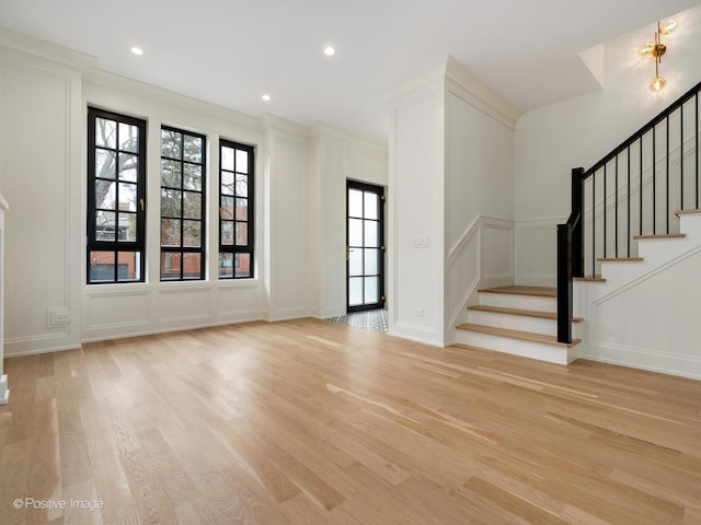 interior space featuring a healthy amount of sunlight, light wood-type flooring, and ornamental molding