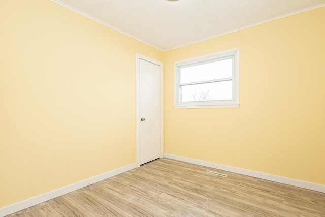 unfurnished room featuring light wood-type flooring and ornamental molding