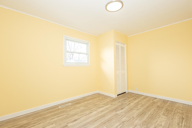 empty room featuring light hardwood / wood-style flooring and ornamental molding