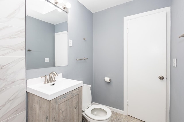 bathroom with vanity, toilet, and a skylight