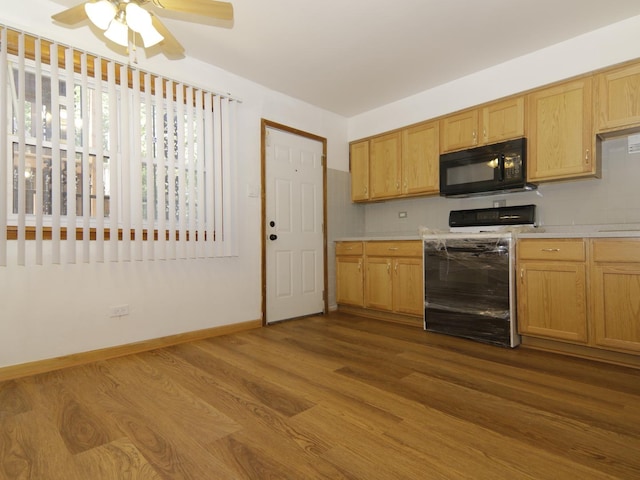 7251 S Ridgeland Ave Unit E, Chicago, IL 60649 - kitchen with black microwave, stove, dark wood-style floors, light countertops, and a ceiling fan