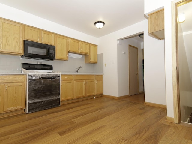 7251 S Ridgeland Ave Unit E, Chicago, IL 60649 - kitchen featuring black microwave, stove, light countertops, light wood-style flooring, and tasteful backsplash