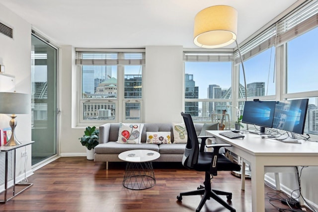 office with dark hardwood / wood-style flooring and a wall of windows