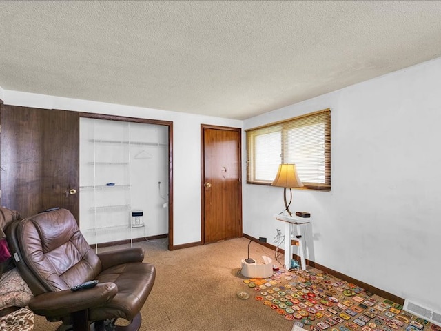 living area featuring light colored carpet and a textured ceiling