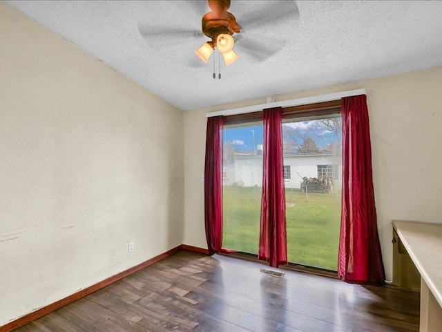 unfurnished room featuring a textured ceiling, ceiling fan, and dark hardwood / wood-style floors