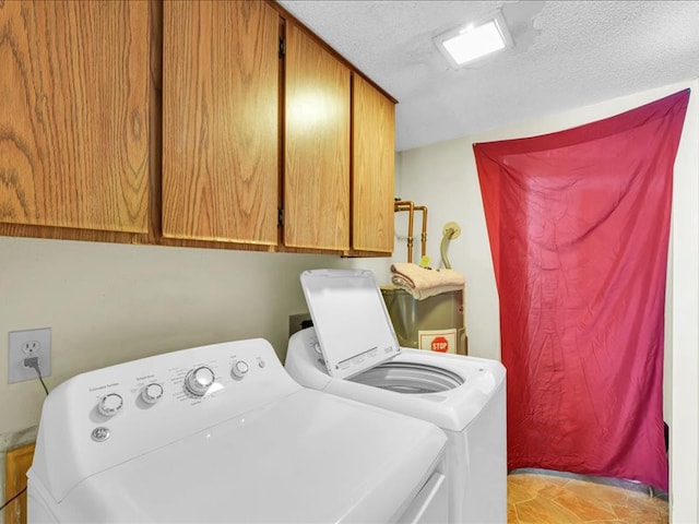 laundry room with water heater, cabinets, a textured ceiling, and independent washer and dryer