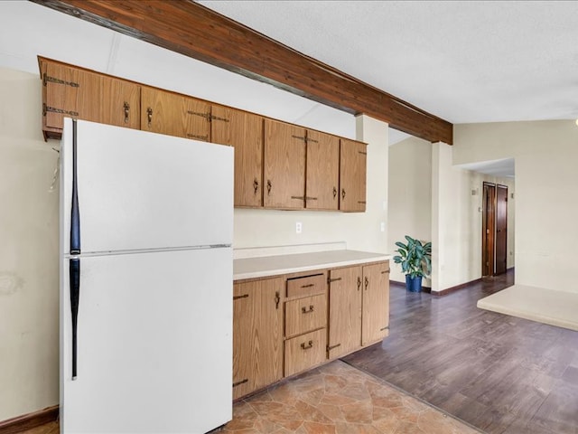 kitchen featuring vaulted ceiling with beams, white refrigerator, and dark wood-type flooring