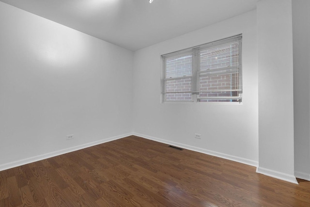 spare room with dark wood-type flooring