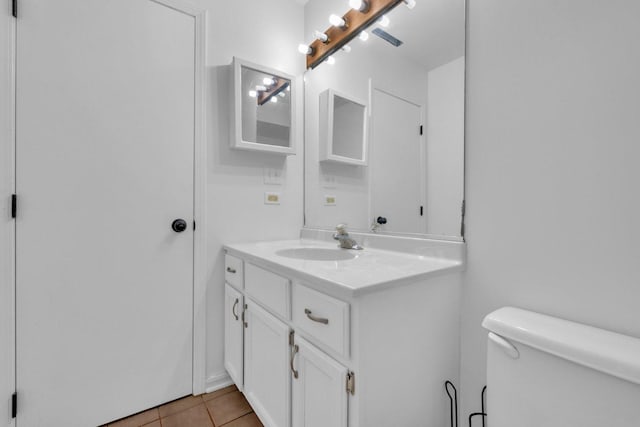 bathroom featuring tile patterned flooring, vanity, and toilet