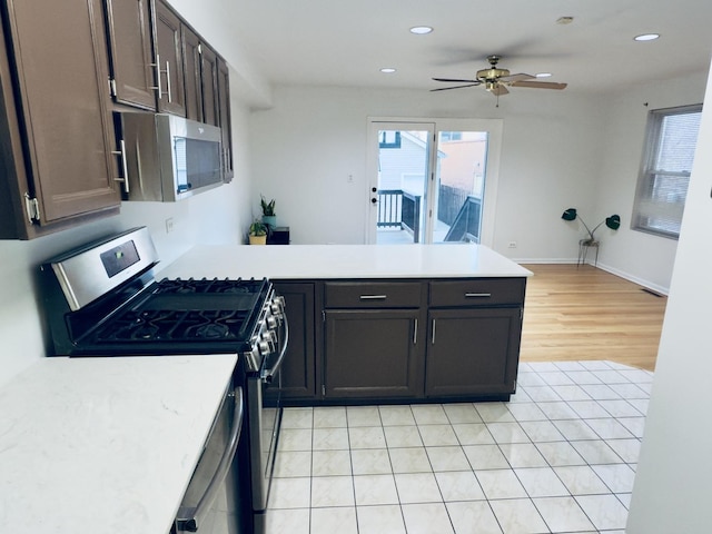 kitchen with appliances with stainless steel finishes, light hardwood / wood-style floors, dark brown cabinets, and ceiling fan