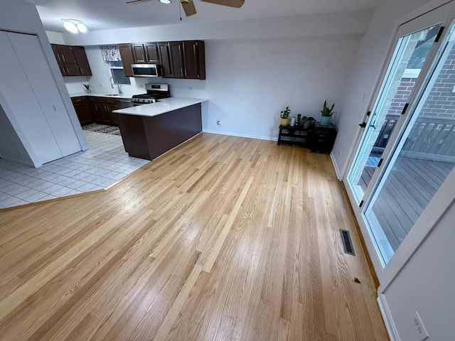 kitchen with sink, light hardwood / wood-style flooring, ceiling fan, dark brown cabinets, and stainless steel appliances