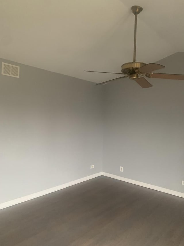 empty room with ceiling fan and dark hardwood / wood-style flooring