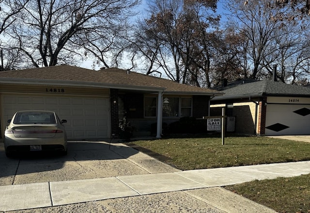 ranch-style home with a garage and a front lawn