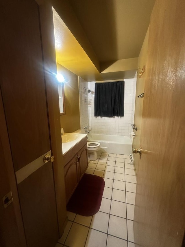 full bathroom featuring tile patterned floors, toilet, tiled shower / bath combo, and vanity