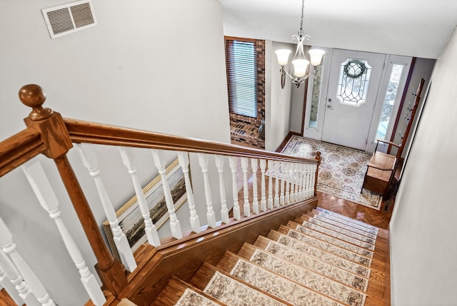 entryway featuring parquet flooring and a chandelier