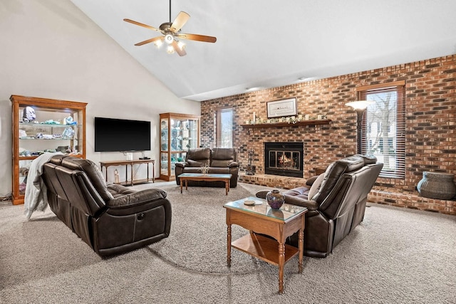 carpeted living room with ceiling fan, brick wall, a fireplace, and high vaulted ceiling