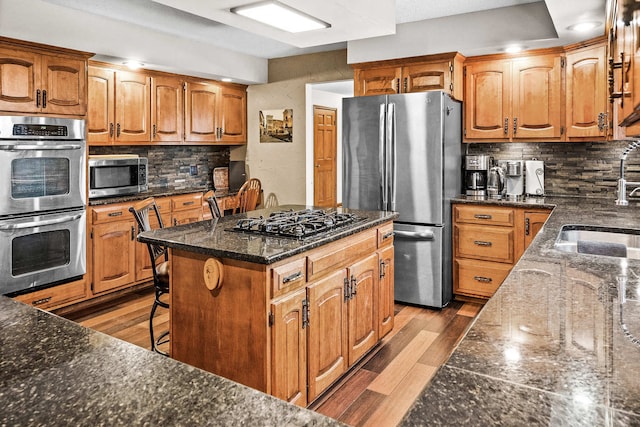 kitchen with light wood-type flooring, stainless steel appliances, a breakfast bar, and a center island