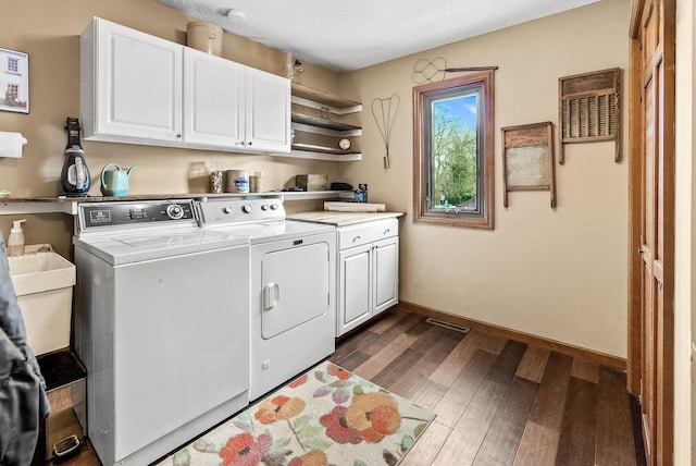 laundry room featuring dark hardwood / wood-style flooring, cabinets, and washer and dryer