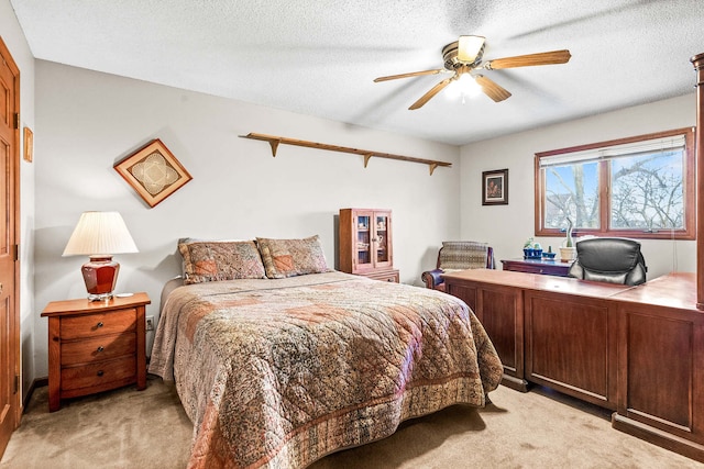 bedroom featuring ceiling fan, light colored carpet, and a textured ceiling