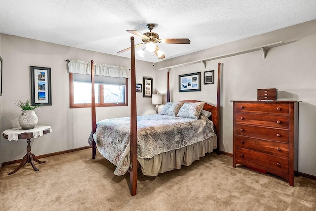 bedroom featuring ceiling fan, light colored carpet, and a textured ceiling