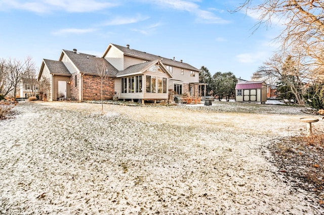 back of property featuring a storage shed and a sunroom