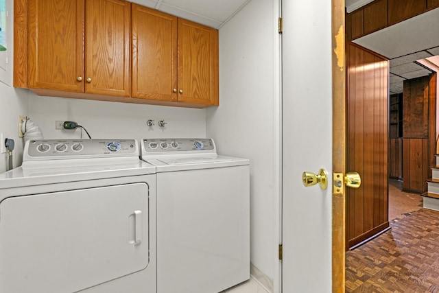 laundry area featuring separate washer and dryer, dark parquet floors, and cabinets