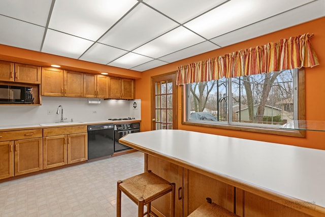 kitchen with a breakfast bar, sink, and black appliances