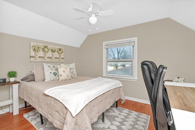 bedroom with ceiling fan, hardwood / wood-style floors, and lofted ceiling