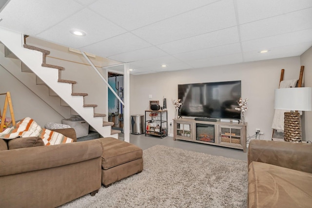 living room featuring a paneled ceiling and concrete floors