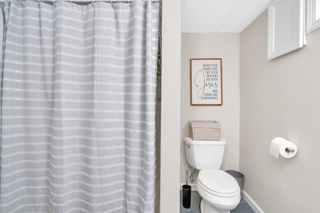 bathroom featuring a paneled ceiling and toilet