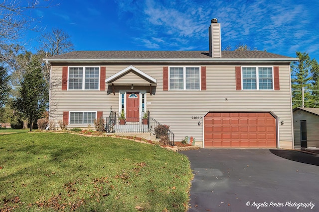 bi-level home with a front yard and a garage