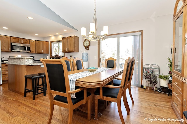 dining area with a notable chandelier, a healthy amount of sunlight, and light wood-type flooring