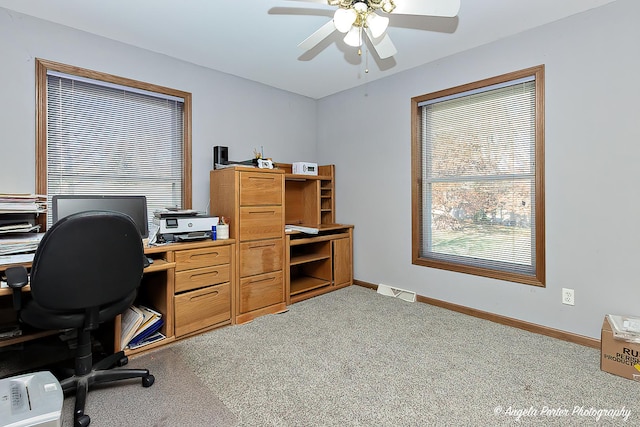 carpeted office space featuring ceiling fan